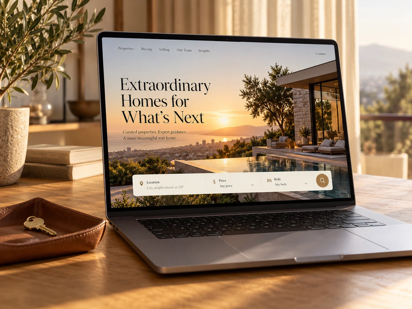 A premium real estate website on a laptop, with a house key on the desk beside it