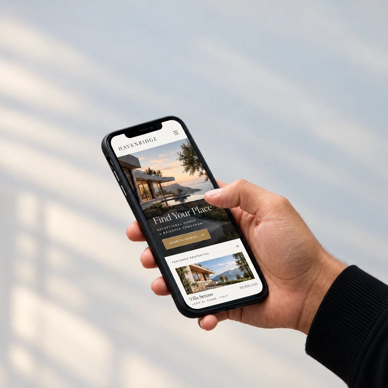 A luxury real estate website open on a phone in a hand