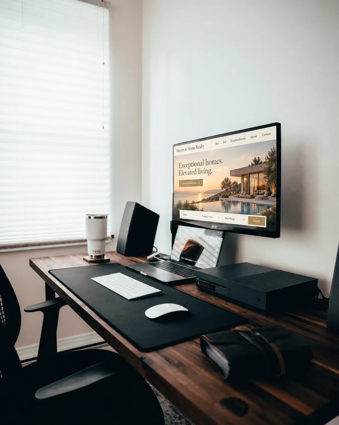 A real estate website open on a monitor at a tidy desk, with search filters ready for a visitor